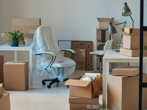 Horizontal image of big light office with new furniture and unpacked cardboard boxes